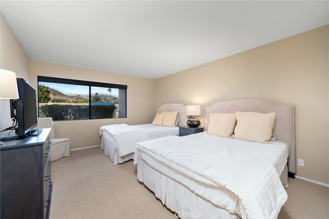 bedroom with light colored carpet and baseboards