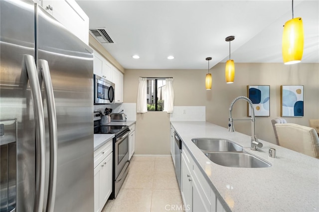 kitchen featuring visible vents, a sink, appliances with stainless steel finishes, white cabinetry, and light stone countertops