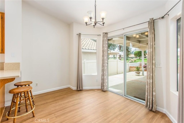 883 Riviera Ave, Banning, CA 92220 - dining area with a chandelier, light wood-type flooring, and baseboards