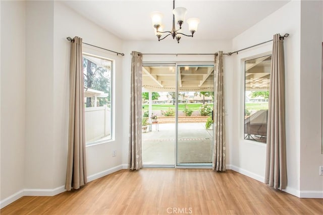 883 Riviera Ave, Banning, CA 92220 - unfurnished dining area featuring a chandelier, light wood-style floors, and baseboards