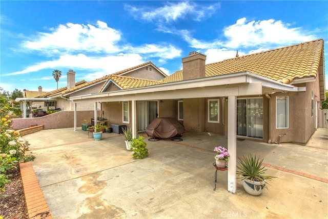 883 Riviera Ave, Banning, CA 92220 - rear view of property with a chimney, stucco siding, a tile roof, and a patio area