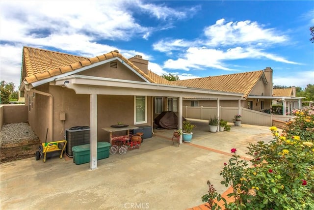 883 Riviera Ave, Banning, CA 92220 - rear view of house featuring central AC unit, a fenced backyard, stucco siding, a patio area, and a chimney