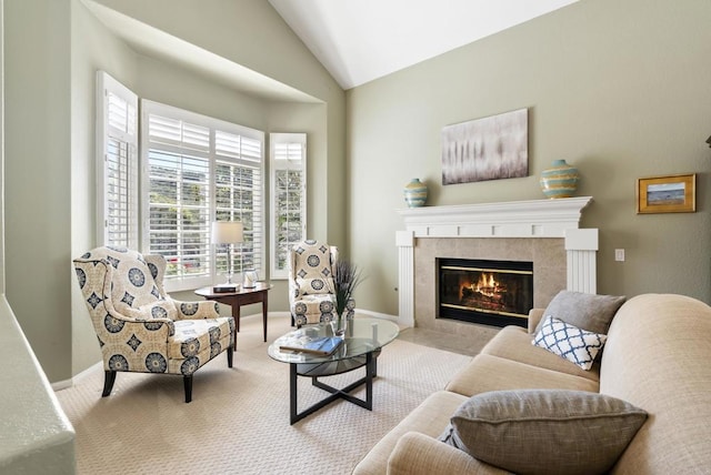 living area with a fireplace, vaulted ceiling, carpet, and baseboards