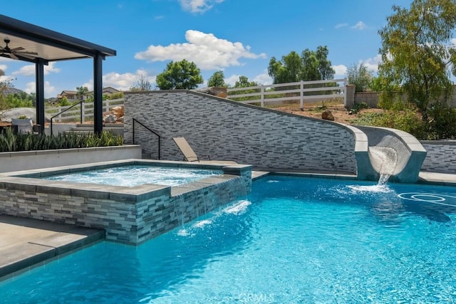 view of swimming pool with fence and a pool with connected hot tub