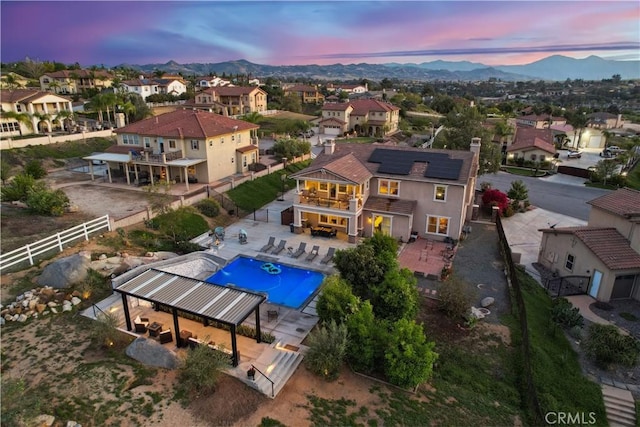 aerial view at dusk featuring a mountain view and a residential view