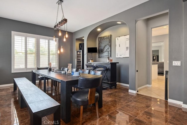 dining area with arched walkways and baseboards