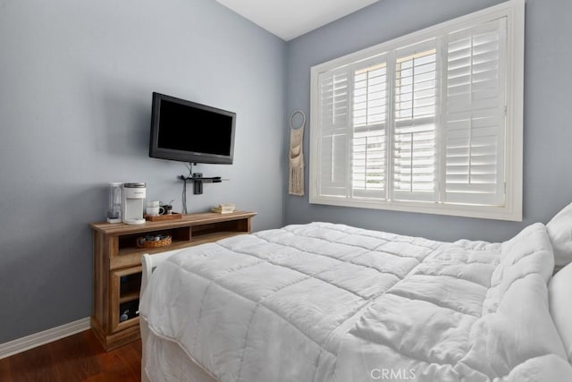 bedroom featuring baseboards and dark wood-style flooring