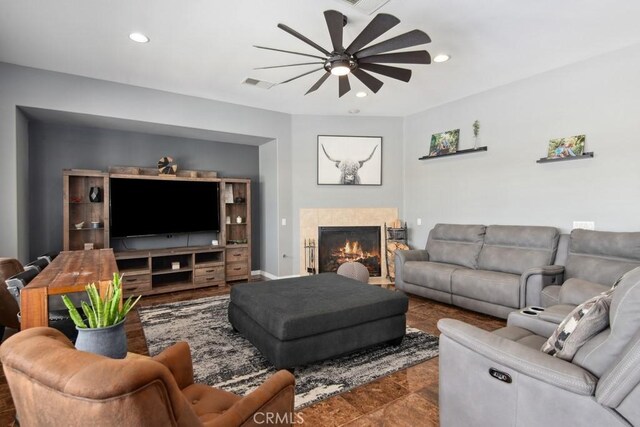 living area with recessed lighting, a tile fireplace, visible vents, and ceiling fan