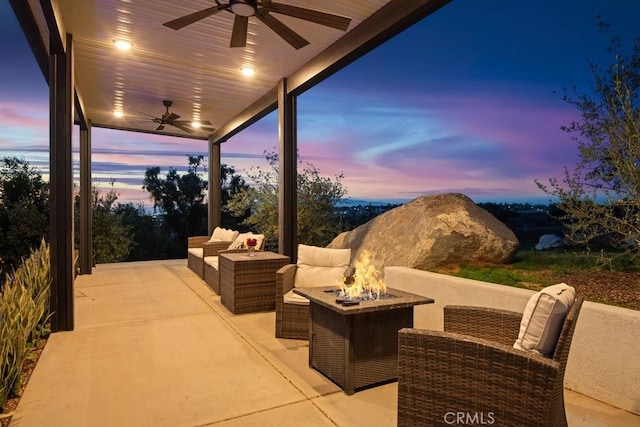 patio terrace at dusk featuring an outdoor living space with a fire pit and a ceiling fan