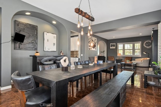 dining area with recessed lighting, arched walkways, and baseboards