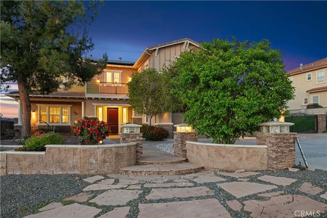 16550 Catalonia Dr, Riverside, CA 92504 - view of front of house with a balcony, roof mounted solar panels, a porch, and stucco siding