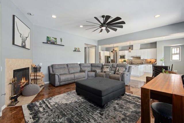 16550 Catalonia Dr, Riverside, CA 92504 - living room with a ceiling fan, recessed lighting, a tiled fireplace, and baseboards