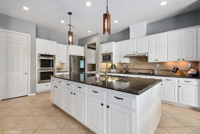 kitchen featuring light tile patterned floors, a sink, stainless steel appliances, and decorative backsplash