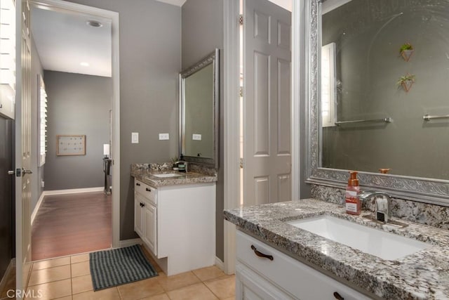 bathroom with two vanities, a sink, and tile patterned floors