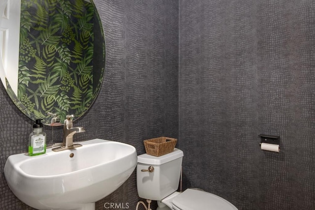 half bath with toilet and a sink