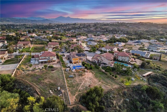 16550 Catalonia Dr, Riverside, CA 92504 - aerial view of property and surrounding area featuring a mountain backdrop and nearby suburban area