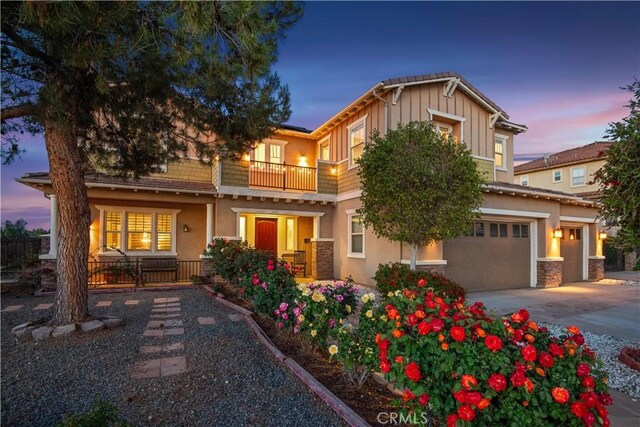16550 Catalonia Dr, Riverside, CA 92504 - craftsman-style home featuring a balcony, stucco siding, an attached garage, driveway, and stone siding