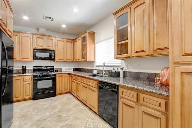 kitchen featuring a sink, light tile patterned floors, glass insert cabinets, black appliances, and visible vents