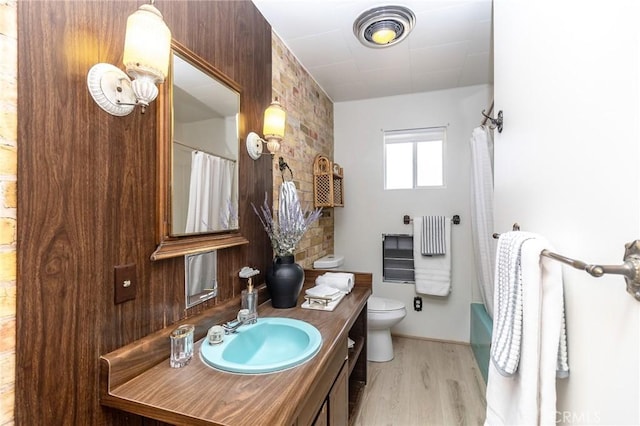 full bath featuring toilet, vanity, and wood finished floors