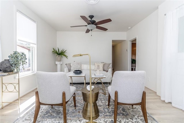 living area with light wood-style flooring and ceiling fan