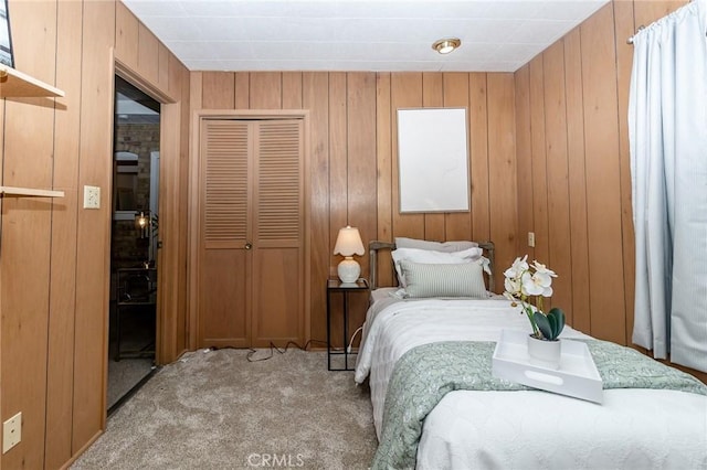 carpeted bedroom featuring a closet and wood walls