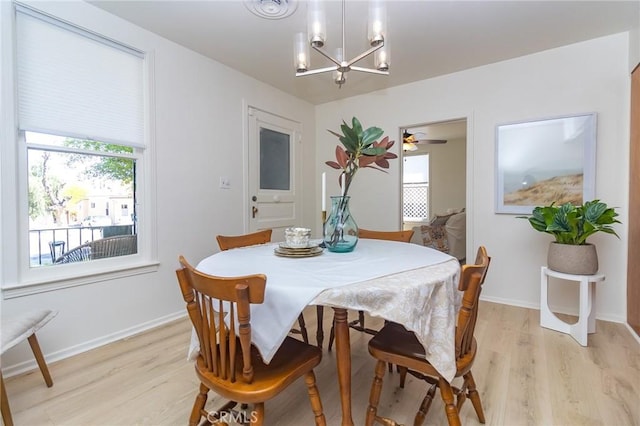 dining space with plenty of natural light, light wood-type flooring, and an inviting chandelier