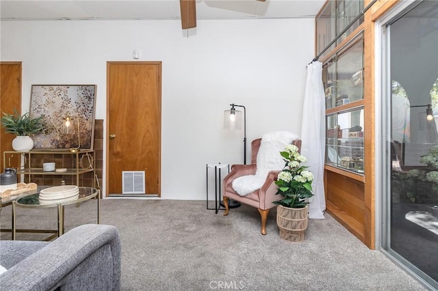 sitting room with visible vents, a ceiling fan, and carpet floors