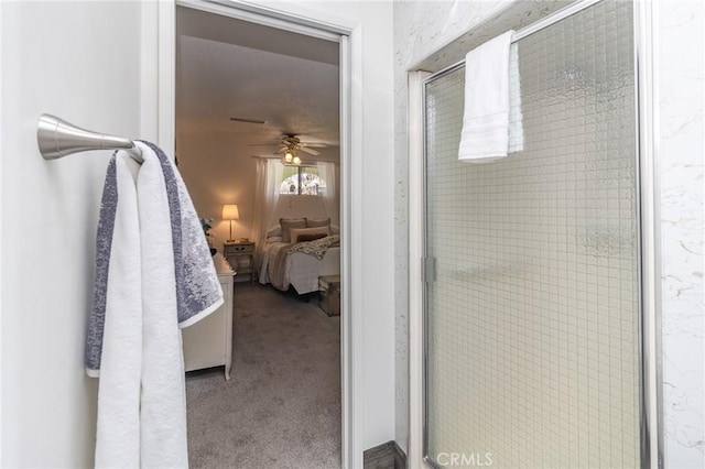ensuite bathroom featuring a shower stall, ceiling fan, and ensuite bath