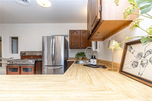 kitchen with a sink, visible vents, light countertops, and stainless steel appliances