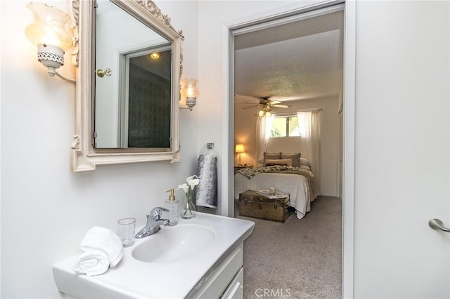ensuite bathroom with a textured ceiling, ensuite bathroom, a ceiling fan, and vanity