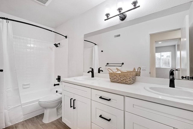 full bath featuring wood finished floors, visible vents, a sink, and toilet