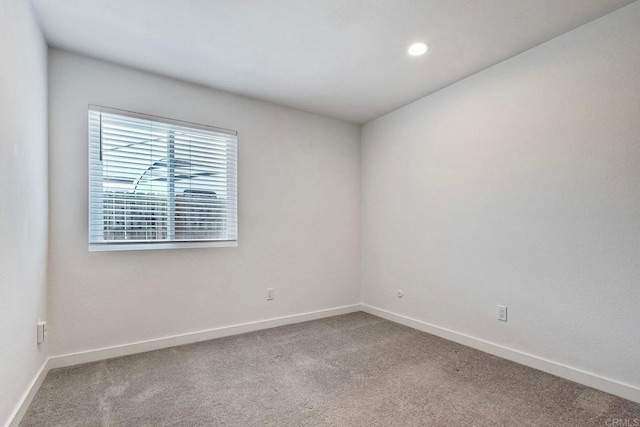 carpeted empty room featuring baseboards and recessed lighting