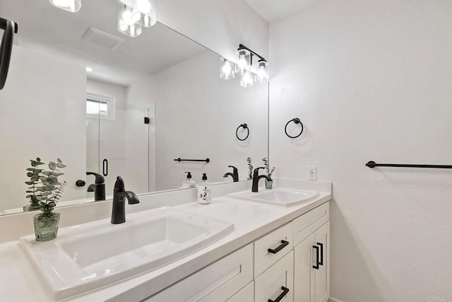 bathroom featuring a sink, a shower stall, and double vanity