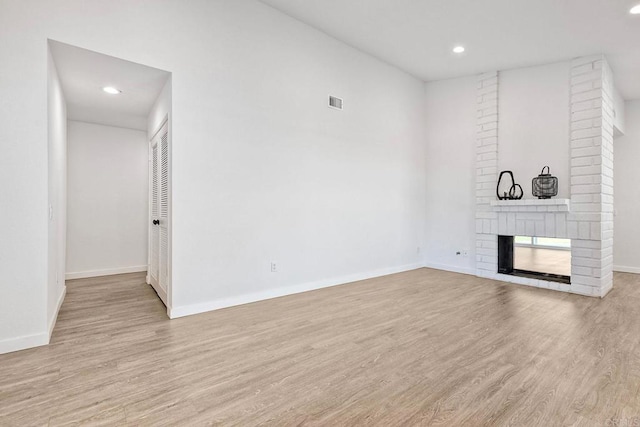 unfurnished living room featuring recessed lighting, wood finished floors, and a fireplace
