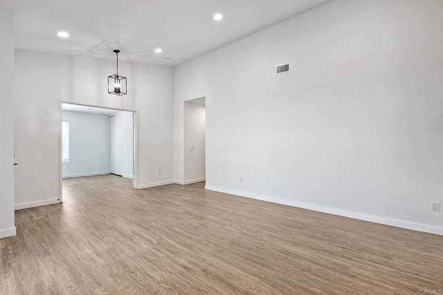 unfurnished room with recessed lighting, light wood-type flooring, visible vents, and baseboards
