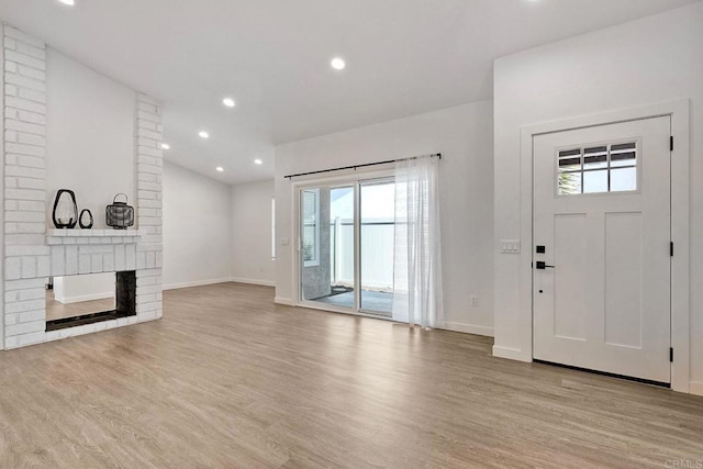 unfurnished living room with light wood-type flooring, baseboards, a fireplace, and recessed lighting