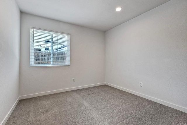 carpeted empty room featuring recessed lighting and baseboards