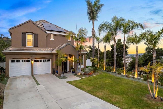 1024 Cottage Way, Encinitas, CA 92024 - mediterranean / spanish-style house featuring an attached garage, a yard, roof mounted solar panels, concrete driveway, and stucco siding