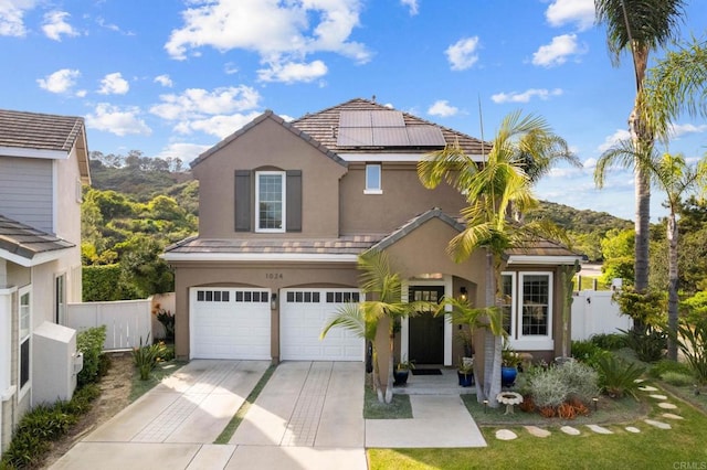1024 Cottage Way, Encinitas, CA 92024 - traditional home with stucco siding, a garage, concrete driveway, roof mounted solar panels, and a tile roof