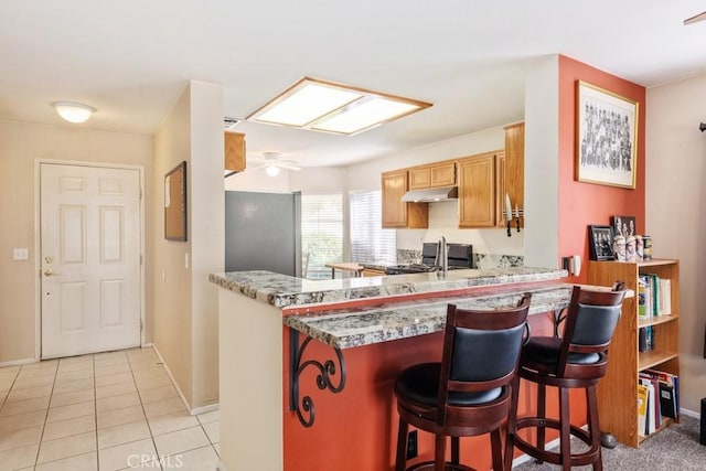 11530 Oak St, Apple Valley, CA 92308 - kitchen featuring under cabinet range hood, range, baseboards, and a kitchen bar