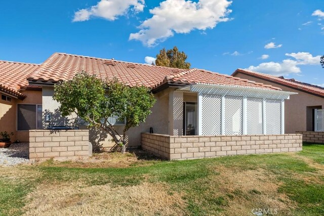 11530 Oak St, Apple Valley, CA 92308 - back of house with a tiled roof, stucco siding, and a lawn