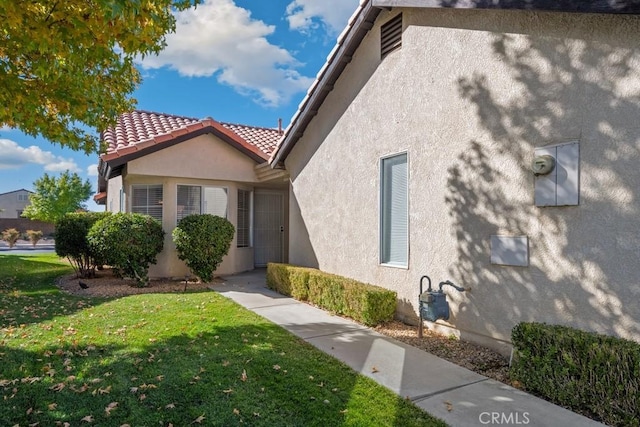 11530 Oak St, Apple Valley, CA 92308 - view of side of property with stucco siding, a yard, and a tiled roof