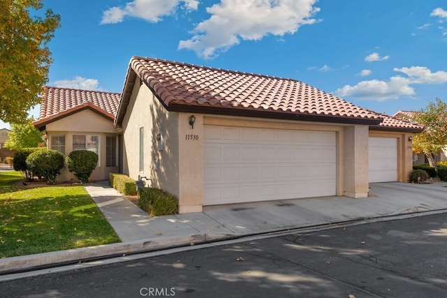 11530 Oak St, Apple Valley, CA 92308 - mediterranean / spanish house featuring a garage, stucco siding, a tiled roof, and driveway