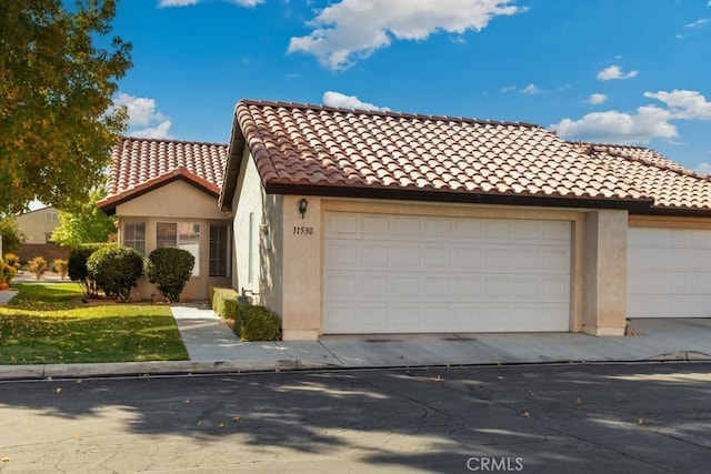 11530 Oak St, Apple Valley, CA 92308 - mediterranean / spanish home with a garage, driveway, a tiled roof, and stucco siding