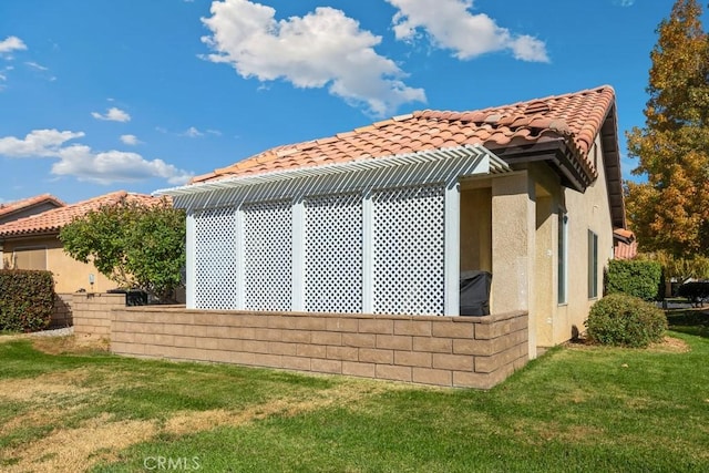 11530 Oak St, Apple Valley, CA 92308 - view of property exterior with stucco siding, a lawn, and a tiled roof