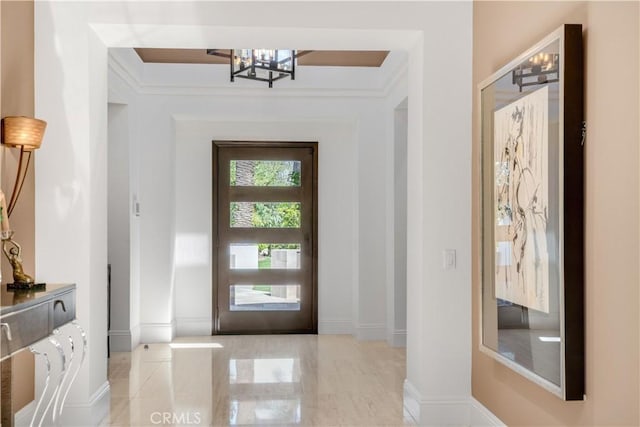 foyer entrance featuring an inviting chandelier and baseboards