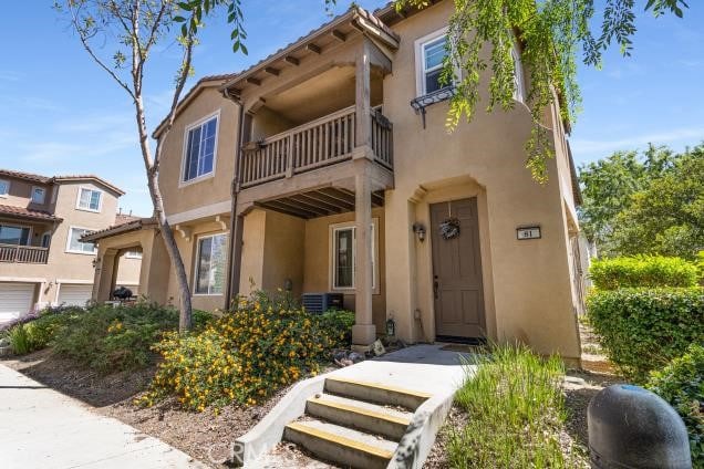 mediterranean / spanish home with a balcony and stucco siding
