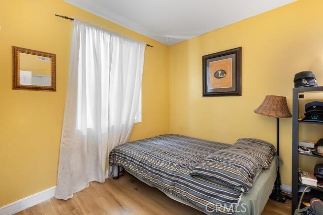 bedroom with baseboards and wood finished floors