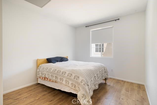 bedroom featuring baseboards and wood finished floors