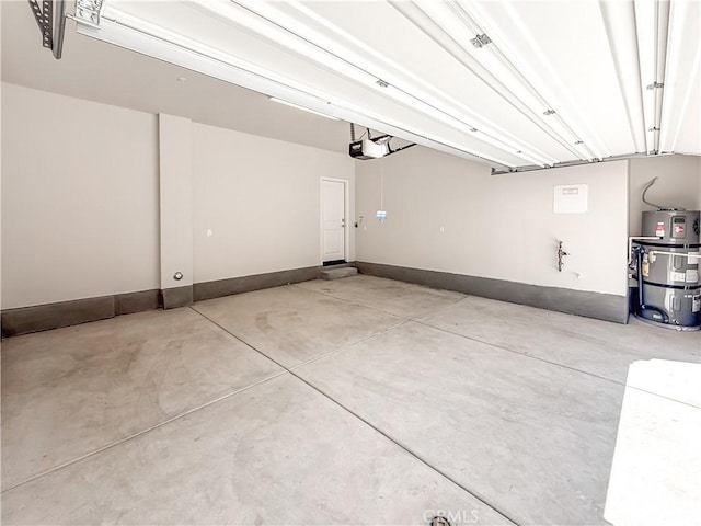 garage with a garage door opener, baseboards, and strapped water heater